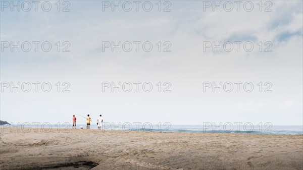 Children playing on beach under cloudy sky