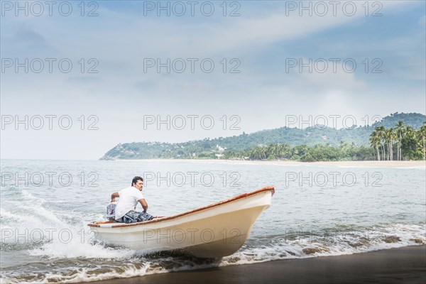 Man steering boat onto beach