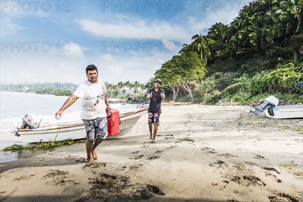 Man carrying fuel can from boat to beach