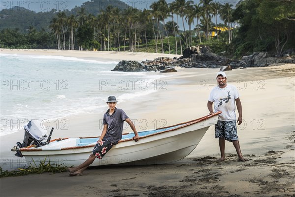 Friends standing near boat on beach