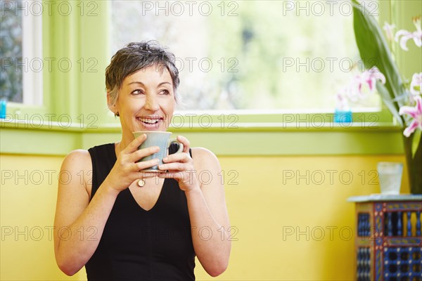 Older Caucasian woman drinking cup of coffee