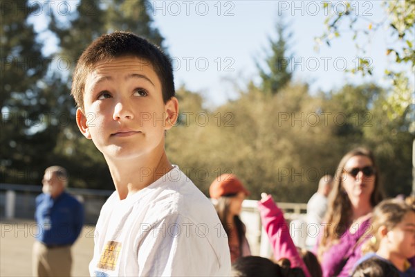 Caucasian student looking up on field trip