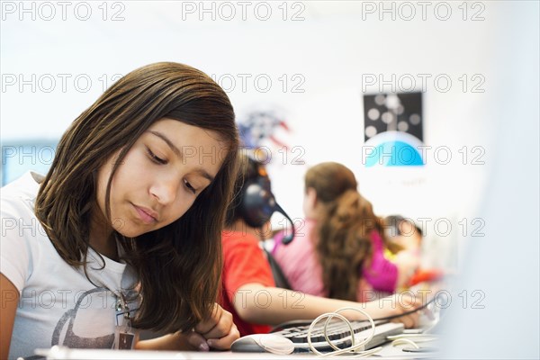 Hispanic student working at desk in classroom