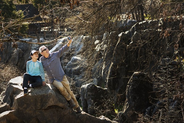 Father and son taking selfie in forest