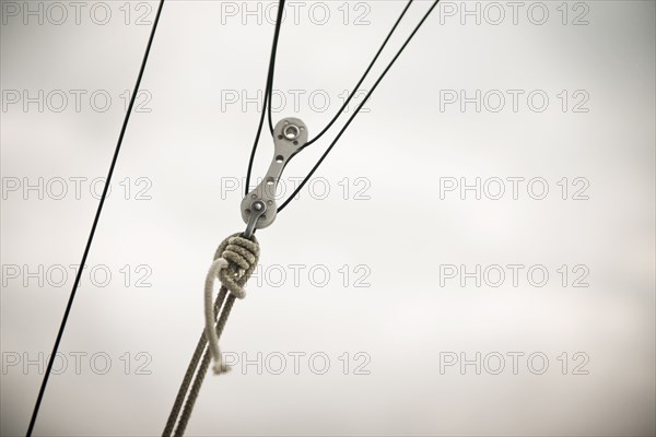 Close up of pulley and ropes under cloudy sky