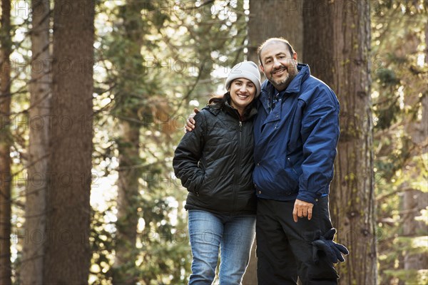 Hispanic couple hugging in forest