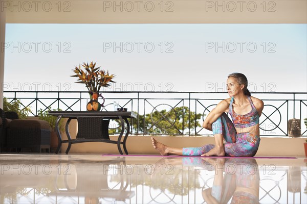 Hispanic woman practicing yoga on balcony