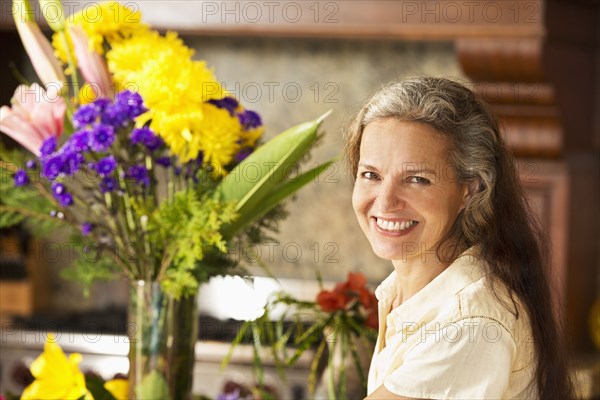 Hispanic woman with flowers in kitchen