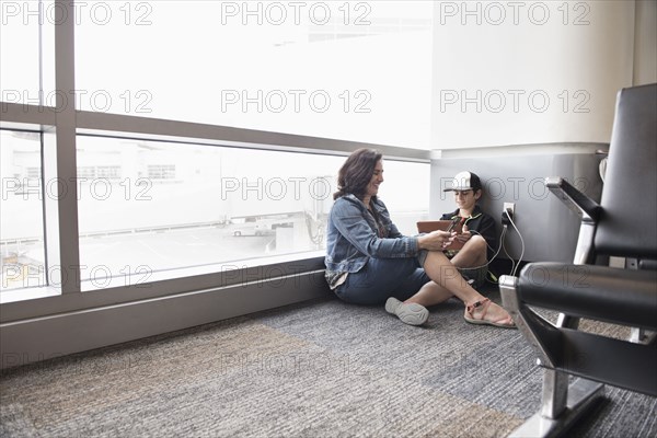 Mother and son using digital tablet in airport