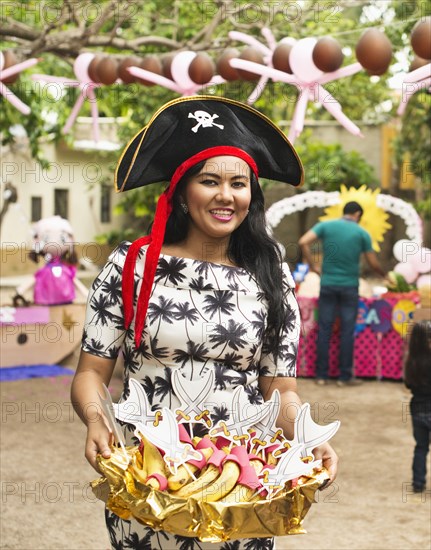 Hispanic woman serving snacks at party