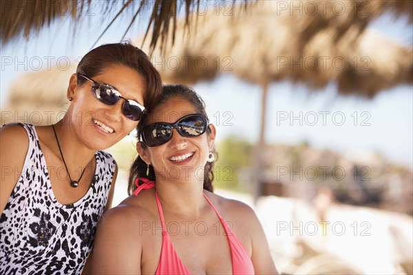 Women wearing sunglasses on tropical beach