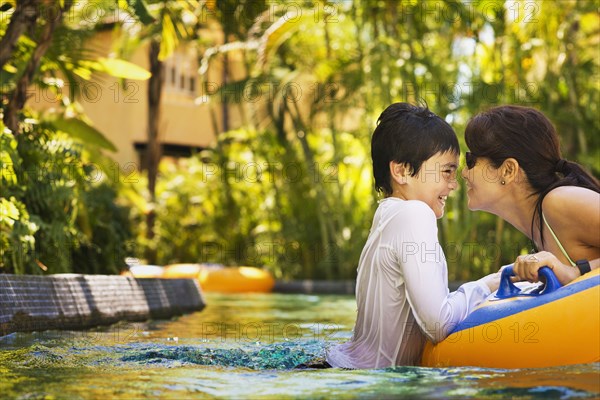 Mother and son swimming in pool