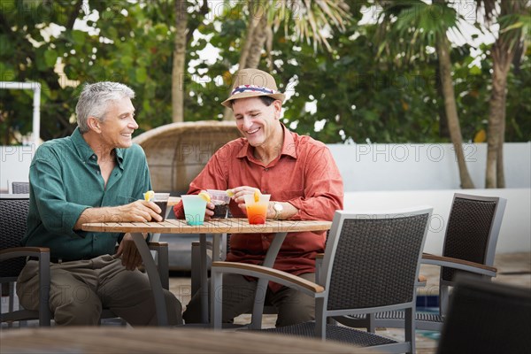 Caucasian men with cocktails on restaurant patio