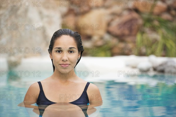 Hispanic woman swimming in pool