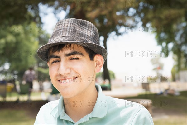 Hispanic teenage boy smiling in park