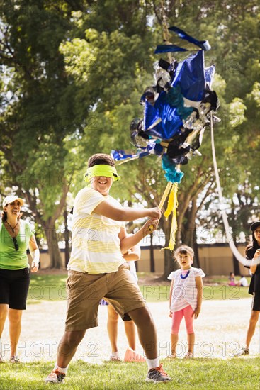 Blindfolded boy hitting pinata at party