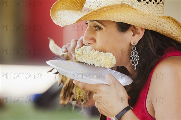 Close up of Hispanic woman eating corn
