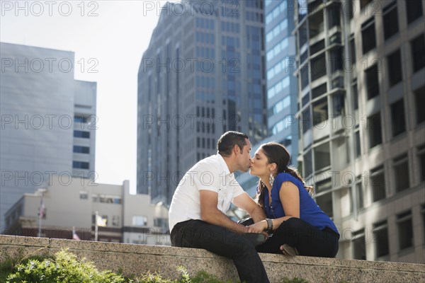 Hispanic couple kissing in city