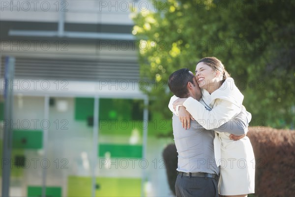 Hispanic couple hugging in city