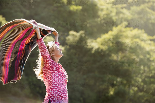 Caucasian woman holding blanket in wind