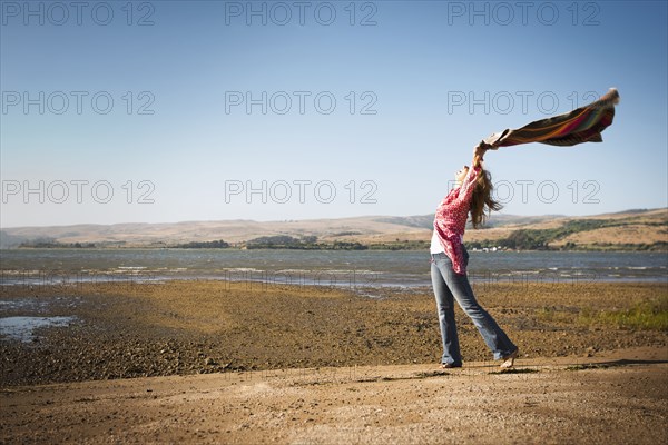 Caucasian woman holding blanket in wind