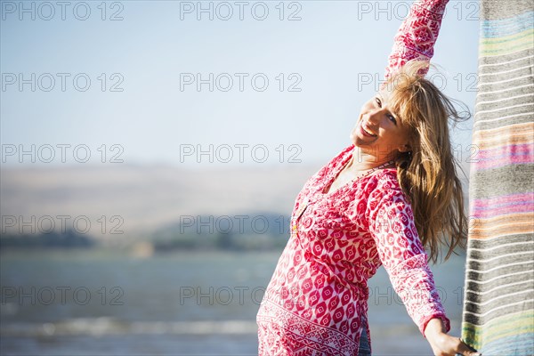 Caucasian woman holding blanket in wind