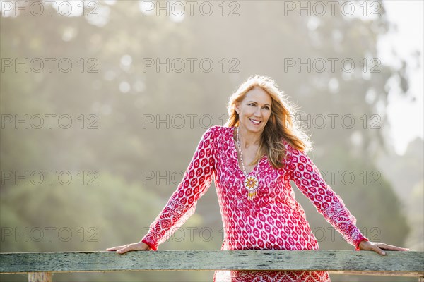 Caucasian woman leaning on wooden banister