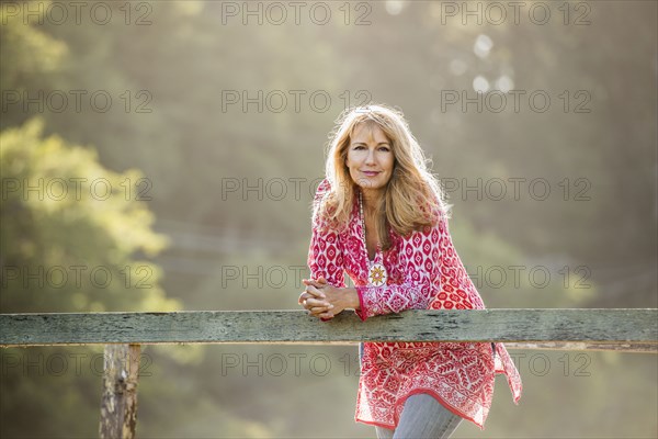 Caucasian woman leaning on wooden banister