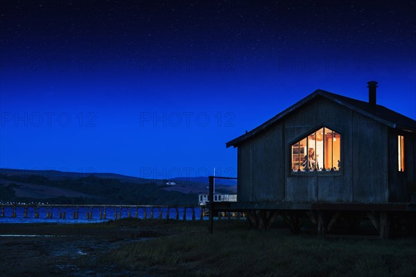 Glowing house and dock over remote lake