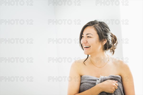 Laughing woman wrapped in towel