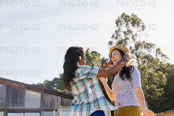 Women trying on hat outdoors