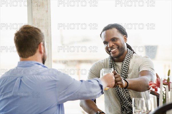 Smiling men toasting indoors