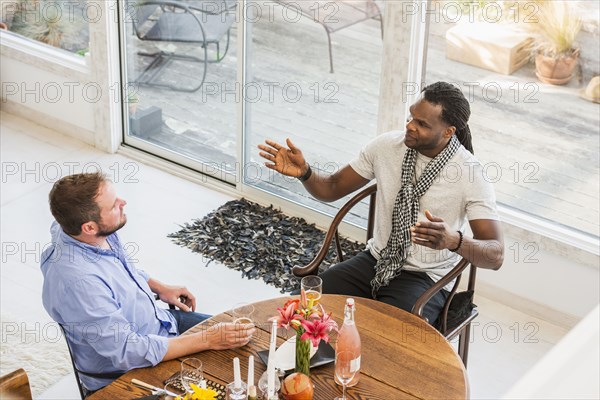 Men talking at dining room table