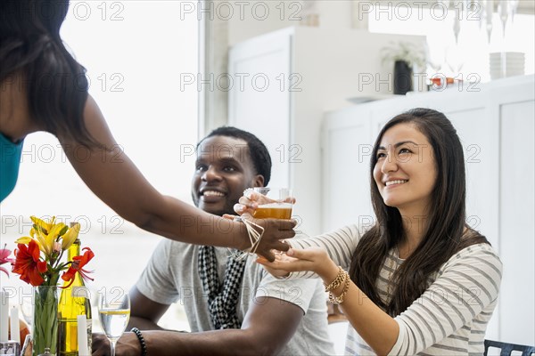 Woman serving friends at dinner party