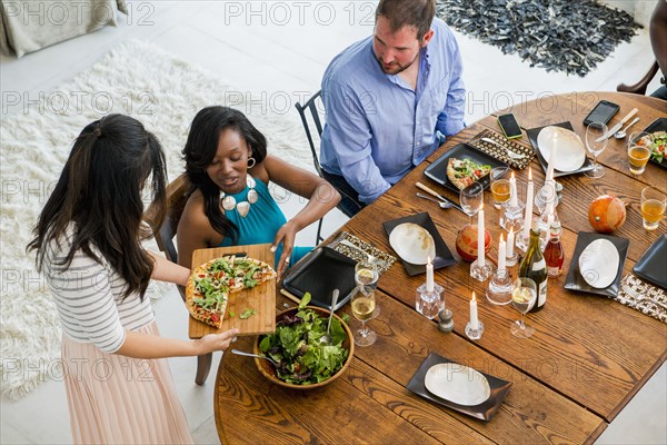 Woman serving friends at dinner party