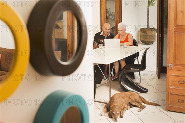 Couple using laptop at table