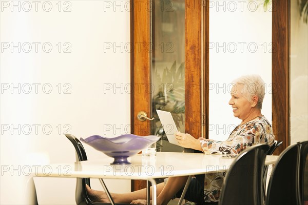 Woman using digital tablet at table