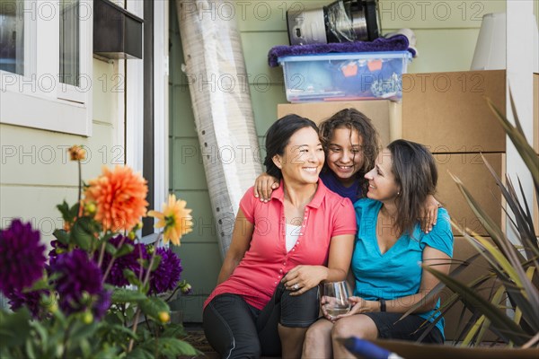 Family hugging outside house