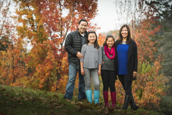 Family smiling on autumn hillside