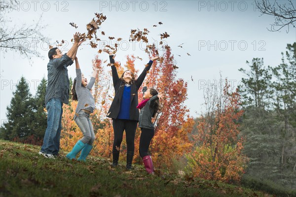 Family playing in autumn leaves