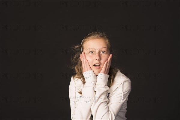 Surprised Caucasian girl with hands on face