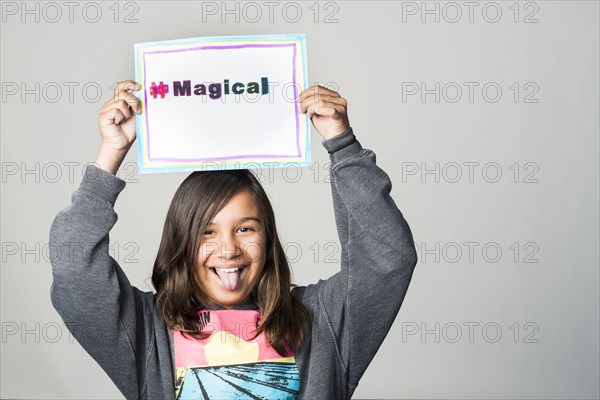 Hispanic girl holding magical sign above head