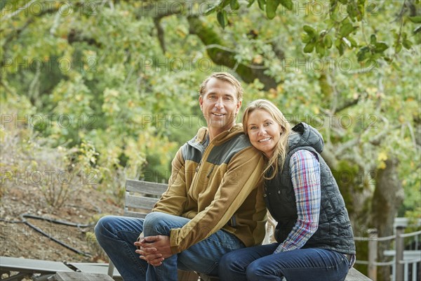 Caucasian couple sitting on bench outdoors