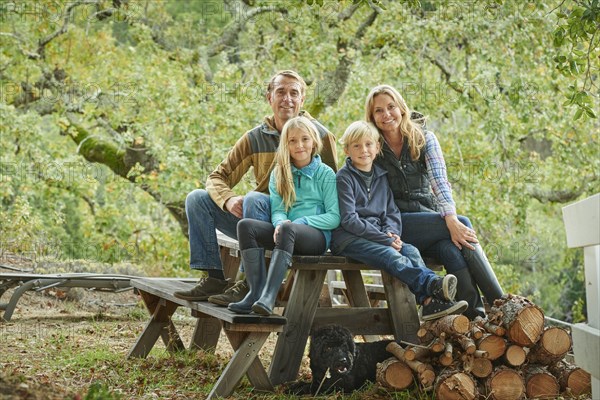 Caucasian family sitting on bench outdoors