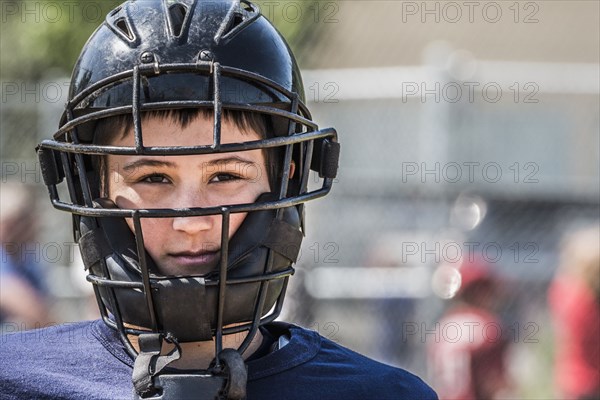 Caucasian boy wearing baseball catchers mask