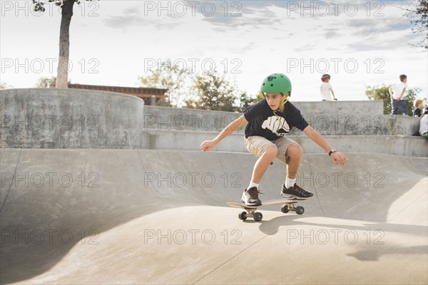 Mixed Race boy skateboarding in skate park