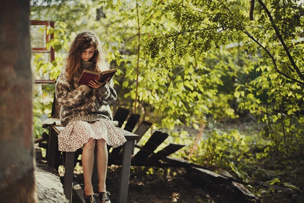 Caucasian girl sitting on table reading book