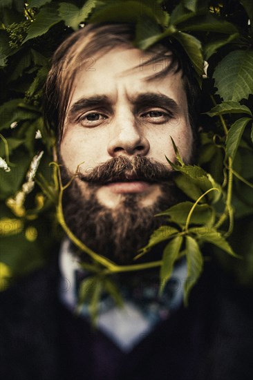 Vine curling around face of man with beard