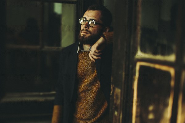 Caucasian an with beard leaning in doorway