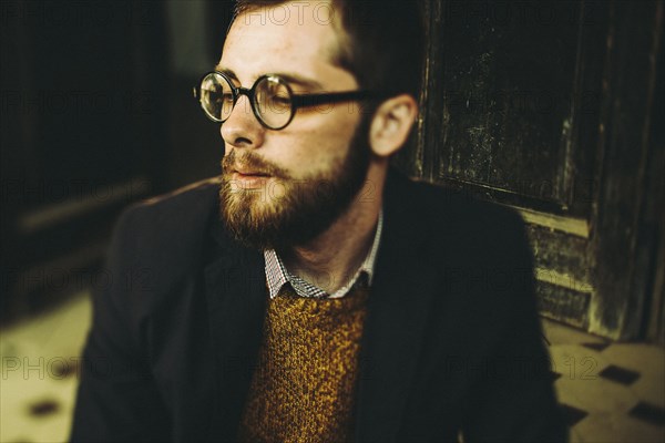 Caucasian man with beard sitting on front stoop